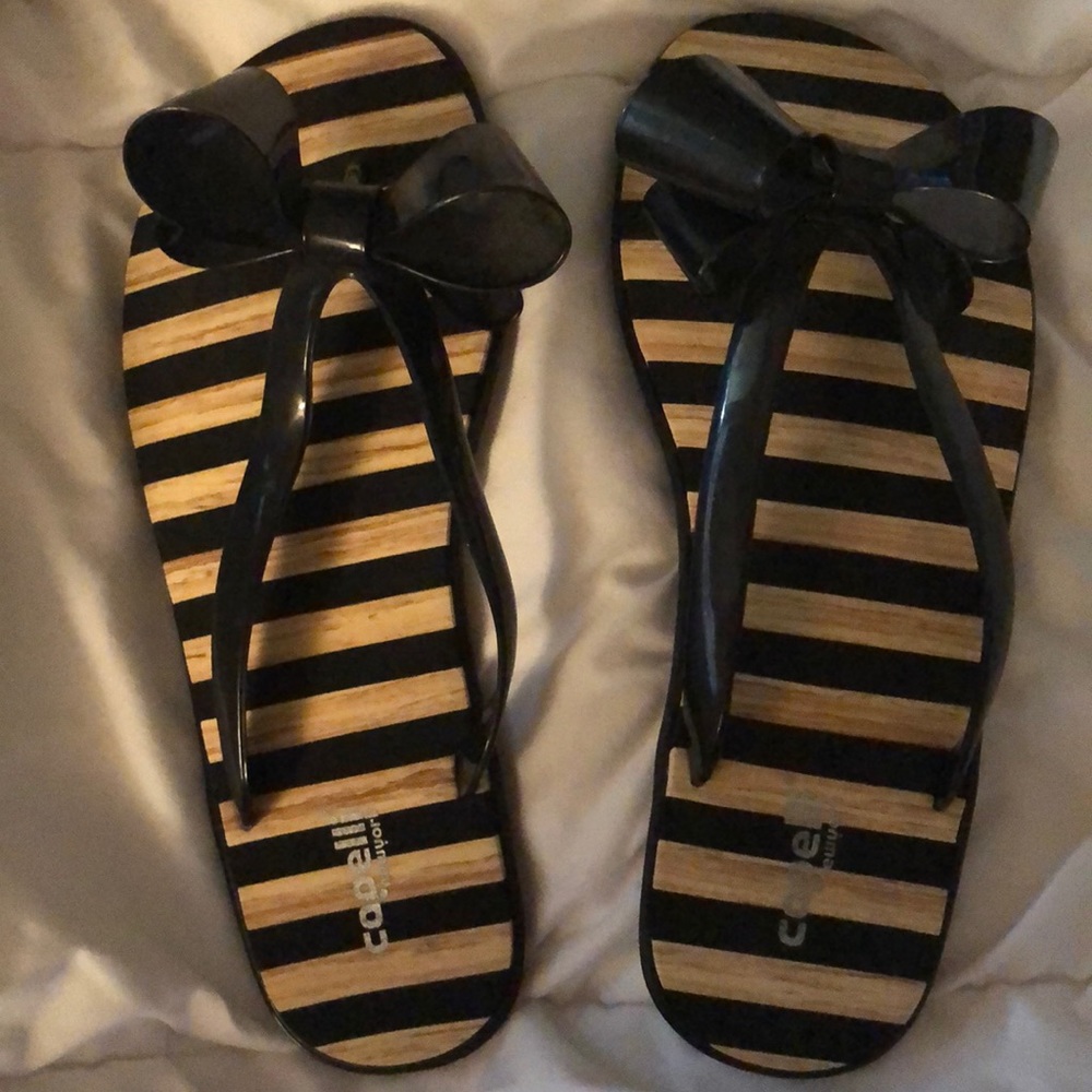 Black and white flip flops with large bows.